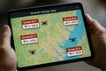 Tablet screen shows drone flight zones and altitudes on a map, tracking multiple drones in real-time with categorized airspace Royalty Free Stock Photo