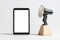 A tablet is sitting on a table next to a large speaker Royalty Free Stock Photo