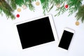 Tablet smart phone display on table on white screen for mockup in Christmas time. Christmas tree, decorations Royalty Free Stock Photo