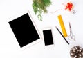 Tablet smart phone on white screen for mockup in Christmas time. Christmas tree, decorations in background Royalty Free Stock Photo