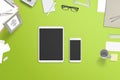 Tablet and smartphone with blank screen for mockup surrounded with stationery and office supplies