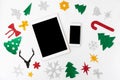 Tablet smartphone christmas composition. christmas decor and colorful handcrafted cutouts on white background. flat lay top view.