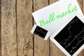 Tablet, smartphone and paper with text bull market on wood table Royalty Free Stock Photo