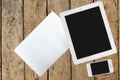 Tablet, smartphone and paper on wood table Royalty Free Stock Photo