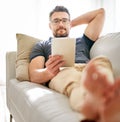 Tablet, sofa and man relaxing at his home reading a ebook or online blog on the internet. Rest, browsing and mature male Royalty Free Stock Photo