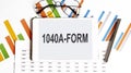 The tablet with text 1040 A FORM on the business charts,glasses and pen Royalty Free Stock Photo