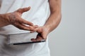 Tablet with a touch screen on a light background male hands white t-shirt cropped view Royalty Free Stock Photo