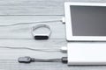 The tablet and tracker are charged from a power bank on a background Royalty Free Stock Photo