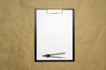 A tablet with a white sheet of A4 format on a beige craft paper Royalty Free Stock Photo