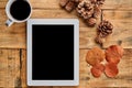 Tablet on wooden table with fall decoration