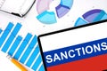 Tablet with word sanctions on the Russian flag Royalty Free Stock Photo