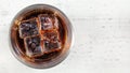 Tabletop photo, glass with cola and four ice cubes on white board, space for text right