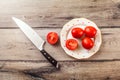 Tabletop photo of tomatoes, one of them cut