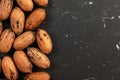 Tabletop photo - whole pecan nuts on black marble like board, space for text right side