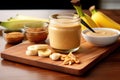 tabletop with smoothie glass, banana and peanut butter spread