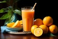 A tabletop tableau glass of orange juice, blue straw, and a heap of oranges