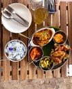 Tabletop view of bowl of Blue Butterfly Pea Flower coconut rice served with popular local dishes like chicken curry and sweet and Royalty Free Stock Photo