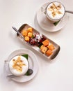 Tabletop view of plated cake snacks or kuihs, served with cappuccinos with foam art. This selection of delicious kuihs are typical Royalty Free Stock Photo