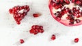 Tabletop view, pomegranate, gem like fruits scattered on white concrete board