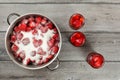 Tabletop view, steel pot with strawberries crystal sugar on top, three bottles with pickled fruit next to it. Homemade strawberry Royalty Free Stock Photo