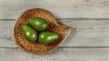 Tabletop view, three avocado pears on wooden carved bowl Royalty Free Stock Photo