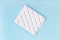 Tablets in blister, pills, drugs, medicine on blue background. Pharmacy, medicine, healthcare concept. Painkiller, vitamin,