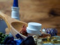 Tablets and capsules in a wooden spoon.