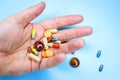 Tablets and pills on the palm of a person. An elderly man holds a lot of colored pills in old hands. Painful old age Royalty Free Stock Photo