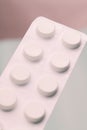 Tablets in a strip against a pink and pastel blue background. Feminine issues. paracetamol. Migraine. Royalty Free Stock Photo