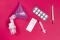 Tablets, syringe, mask inhaler and thermometer on pink background. Medicines for illness. Treatment concept