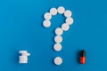 The tablets are white meds on a blue background. A symbol of a question mark. Choose between multiple pills and medical pills Royalty Free Stock Photo