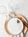 Tableware and decorations for serving table. Ceramic and wooden plates, wine glasses and cutlery with linen napkin on white Royalty Free Stock Photo