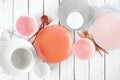 Tableware set in pastel coral, pink, white and grey colors. Overhead on white wood. Royalty Free Stock Photo