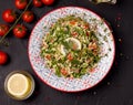 Tabule - oriental salad, close to the ingredients and on a black table