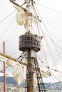 Tackles of an old sailing vessel - a mast, a mast, raised red-white sails, ropes.