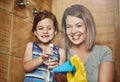 Tackling chores as a mother and daughter team. a mother and her little daughter cleaning a bathroom together at home.