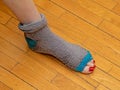 Tacky torn apart sock with foot toes peeking out