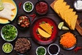 Taco bar table scene with a selection of ingredients on a dark wood background