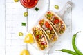 Taco - wheat tortilla with meat, vegetables, corn, greens. Delicious mexican snack on a white wooden background. Royalty Free Stock Photo