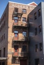 Tacoma, WA USA - circa August 2021: Low angle view of a wooden staircase on the outside of a red brick building, leading to Royalty Free Stock Photo