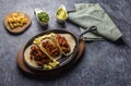 Tacos al pastor on hot skillet ready to prepare with the ingredients of your choice