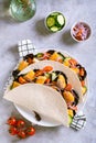 Tacos with chicken nuggets, cucumber, tomato, onion and lettuce on a plate top and vertical view Royalty Free Stock Photo