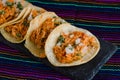 Mexican tacos filled with tinga de pollo on a traditional textile background