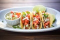 tacos with refried beans, cheese, and pico de gallo garnish