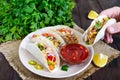 Tacos - wheat tortilla with meat, vegetables, greens and corn with tomato sauce on a dark wooden background. Royalty Free Stock Photo