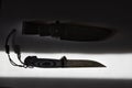Fixed blade tactical knife with sheath on white background in hard light Royalty Free Stock Photo