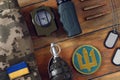 Tactical gear, military uniform and Ukrainian army patches on wooden table, flat lay