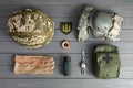 Tactical gear and Ukrainian army patch on grey wooden table, flat lay