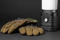 Tactical gloves and camping lantern on black background. Military training equipment