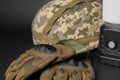 Tactical gloves, helmet and camping lantern on black background, closeup. Military training equipment